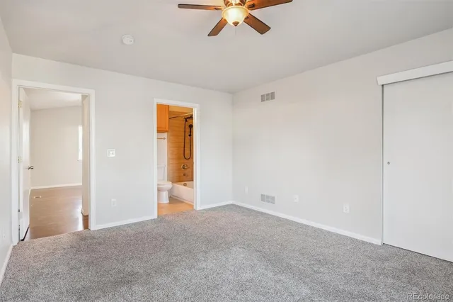 a view of an empty room with a ceiling fan