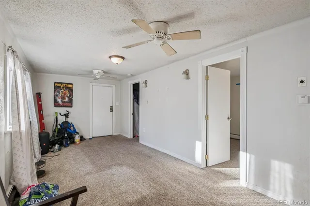 a view of a livingroom with a ceiling fan and entryway