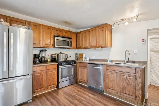 a kitchen with stainless steel appliances granite countertop a stove a sink dishwasher and a refrigerator
