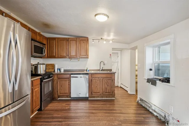 a kitchen with stainless steel appliances granite countertop a refrigerator a stove top oven a sink and dishwasher
