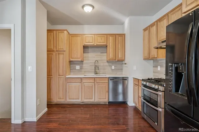 a kitchen with stainless steel appliances granite countertop a stove a sink and a refrigerator