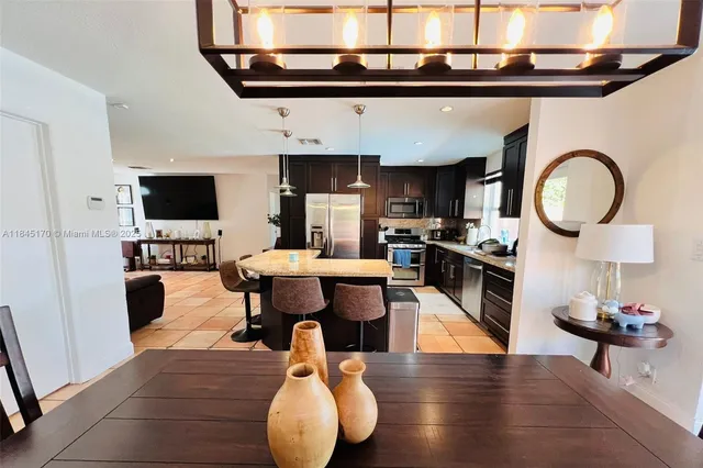 a living room with furniture a flat screen tv and kitchen view