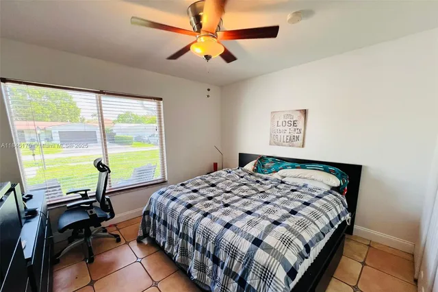 a bedroom with a bed a window and a chandelier