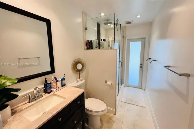 a bathroom with a granite countertop sink toilet and shower