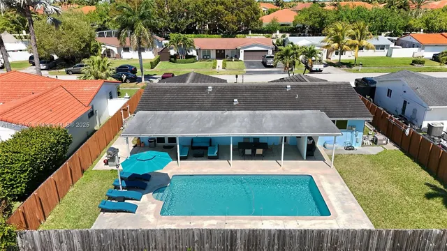 a view of a swimming pool with lawn chairs and plants