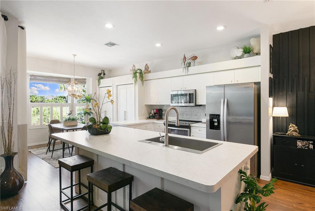 21445 Knighton Run Estero, FL 33928 - Photo 12 of 48 a kitchen with refrigerator and cabinets
