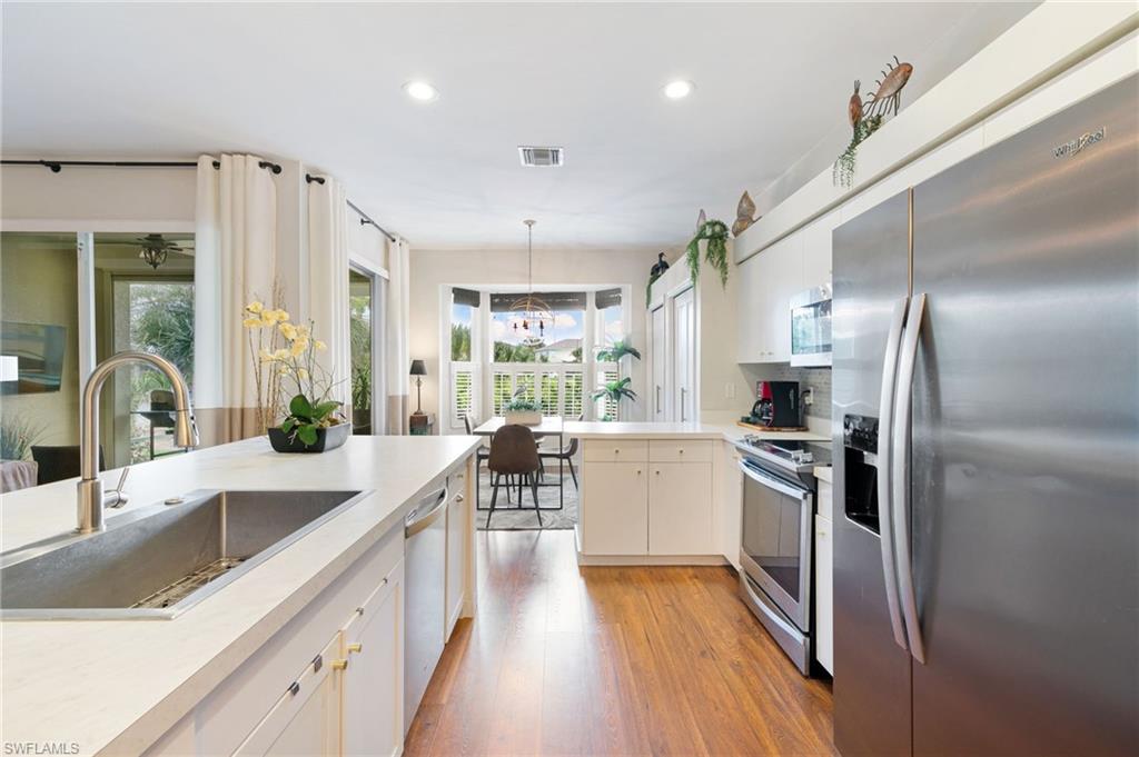 21445 Knighton Run Estero, FL 33928 - Photo 13 of 48 a kitchen with stainless steel appliances granite countertop a sink stove and refrigerator