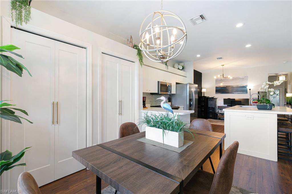21445 Knighton Run Estero, FL 33928 - Photo 15 of 48 a view of a dining room with furniture a chandelier and wooden floor