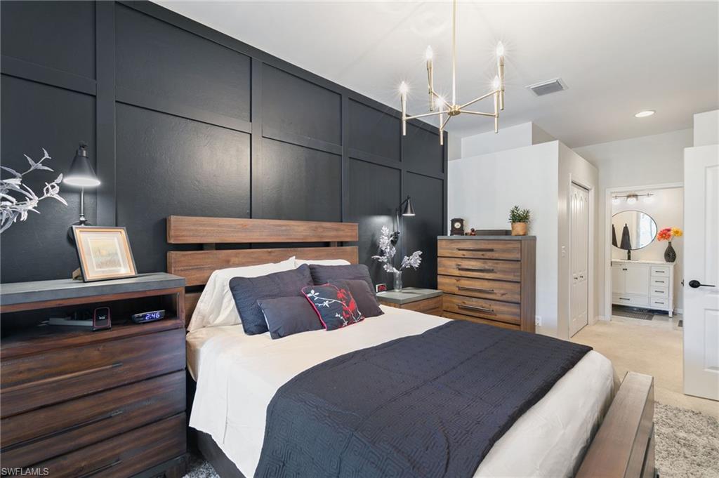 21445 Knighton Run Estero, FL 33928 - Photo 24 of 48 a bedroom with a large bed and a chandelier