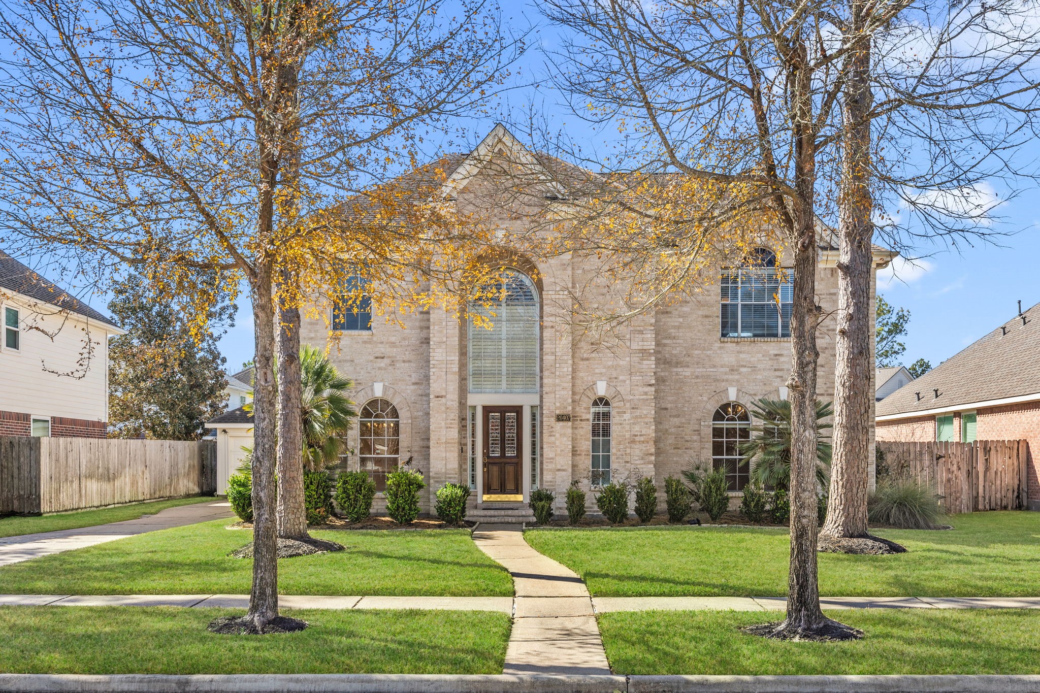 This home boasts impressive curb appeal with its beautiful brick exterior and grand entrance that makes a striking first impression. A long driveway to the left provides ample parking space, perfect for guests or multiple vehicles, while the elegant façade sets the tone for the inviting interior.