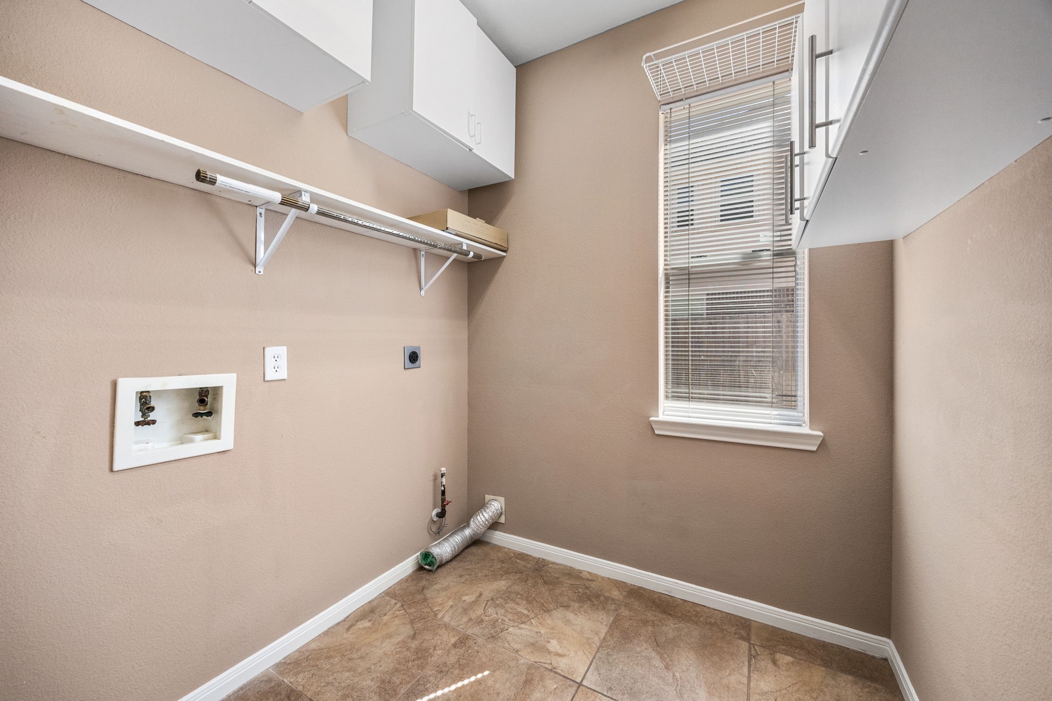 20407 Spring Rose Drive Katy, TX 77450 - Photo 17 of 33 The in-house utility room is generously sized, offering plenty of cabinets and shelving for storage. Designed with convenience in mind, this space makes laundry and organization both easy and efficient.