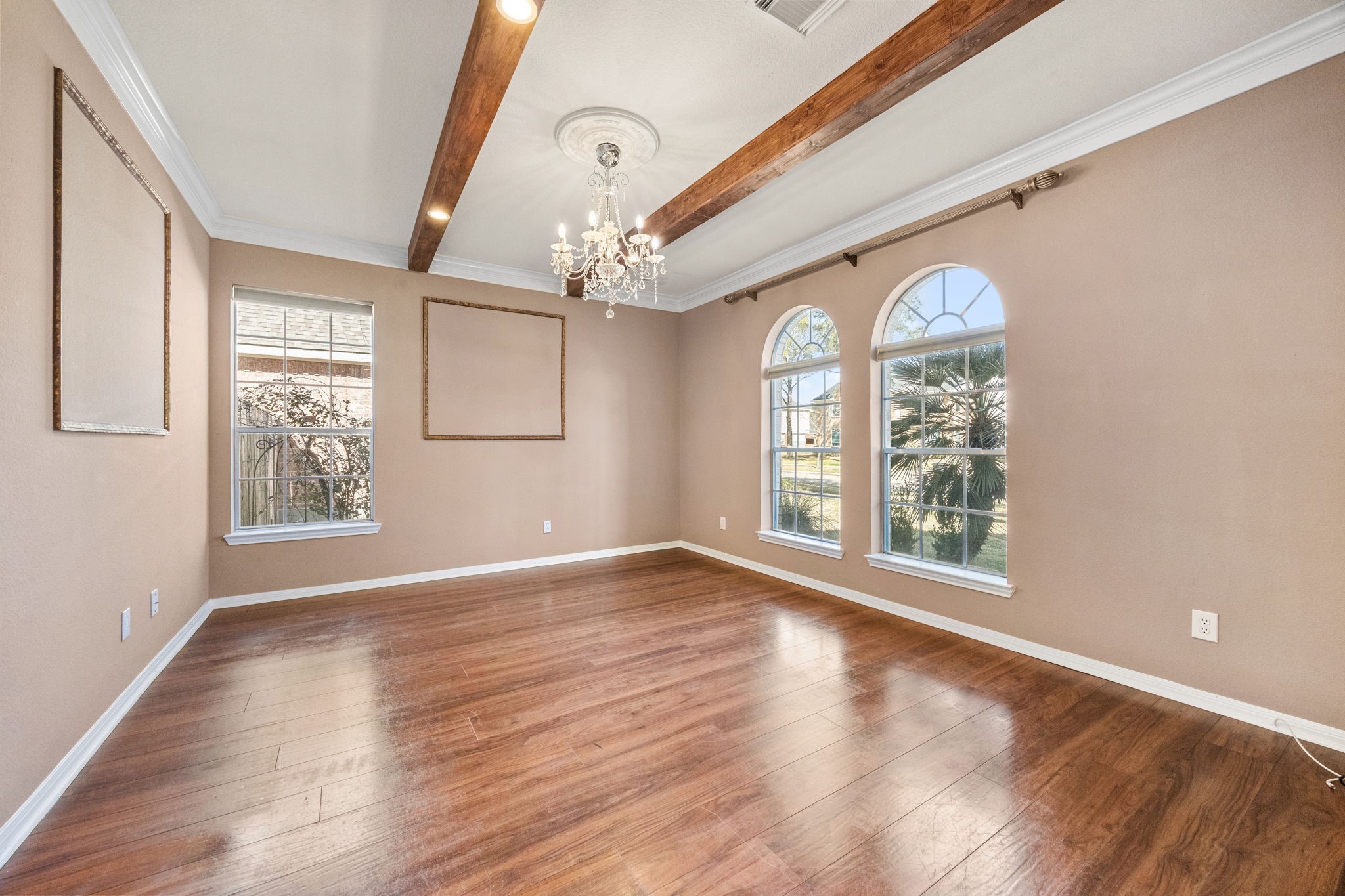20407 Spring Rose Drive Katy, TX 77450 - Photo 8 of 33 To the right of the front door, you’ll find another large, versatile room showcasing beautiful details such as a wood-beamed ceiling and arched windows that fill the space with natural light. This room offers flexibility—perfect as a formal living area, home office, or creative space.