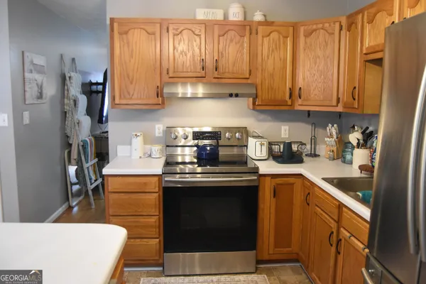 a kitchen with stainless steel appliances granite countertop a stove a sink dishwasher and a refrigerator