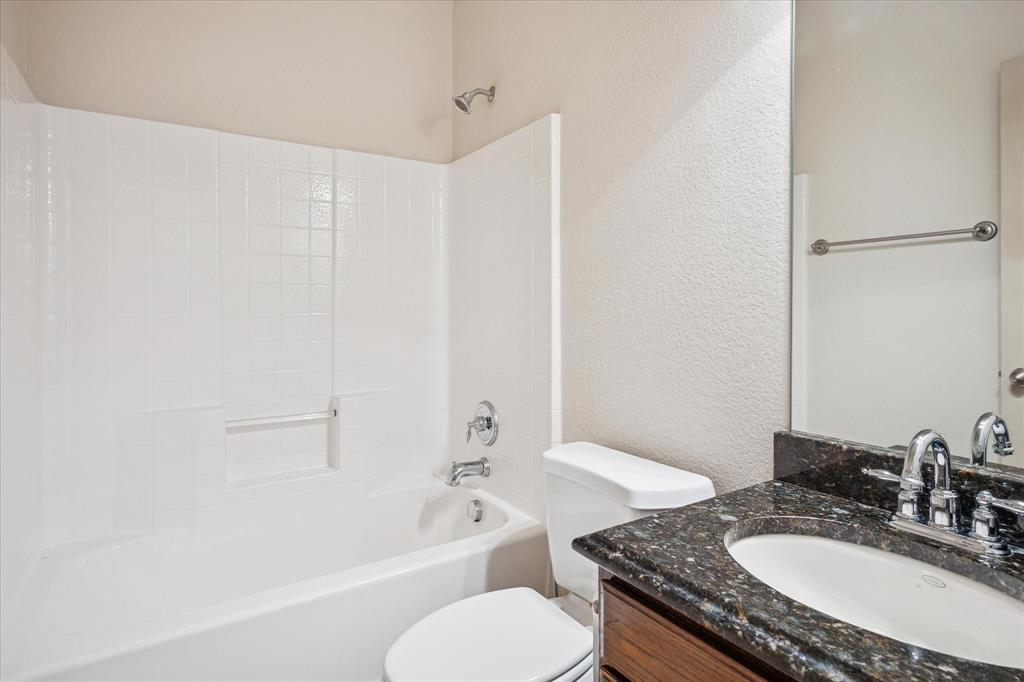 3808 Vienna Street Irving, TX 75038 - Photo 16 of 22 a bathroom with a granite countertop sink toilet and shower