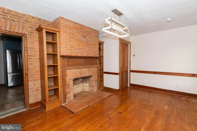 a view of a livingroom with wooden floor and staircase