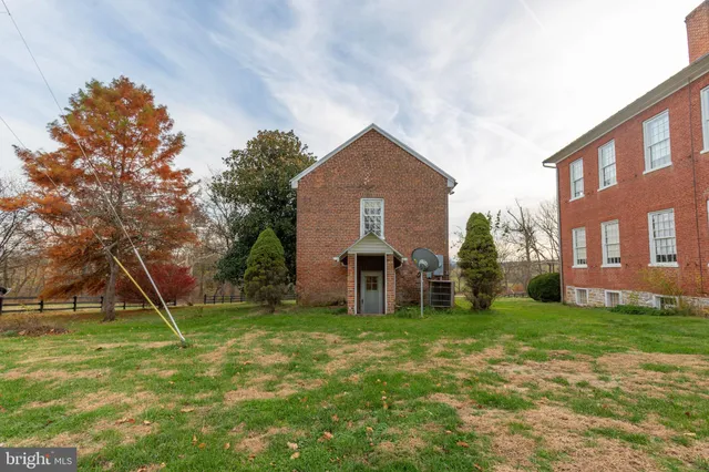 a view of a house with a yard and a tree