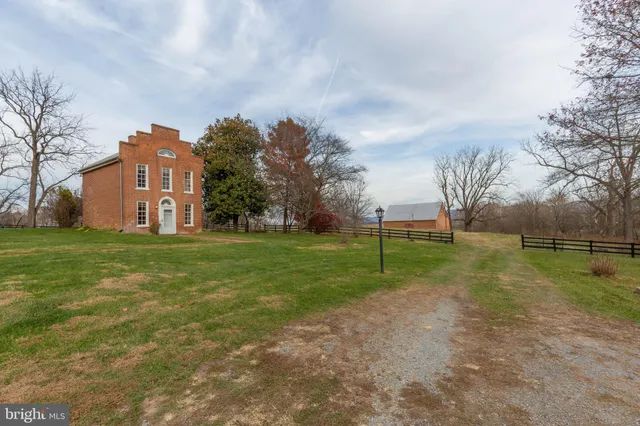 a view of a big house with a big yard and large trees