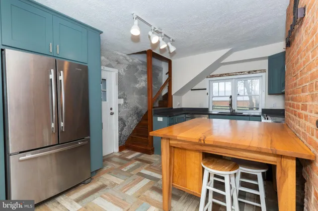 a kitchen with stainless steel appliances a refrigerator and a stove top oven