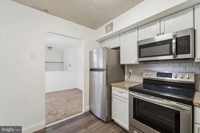 a kitchen with stainless steel appliances a stove microwave and refrigerator