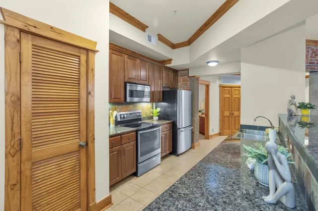 a large kitchen with granite countertop a sink and a refrigerator