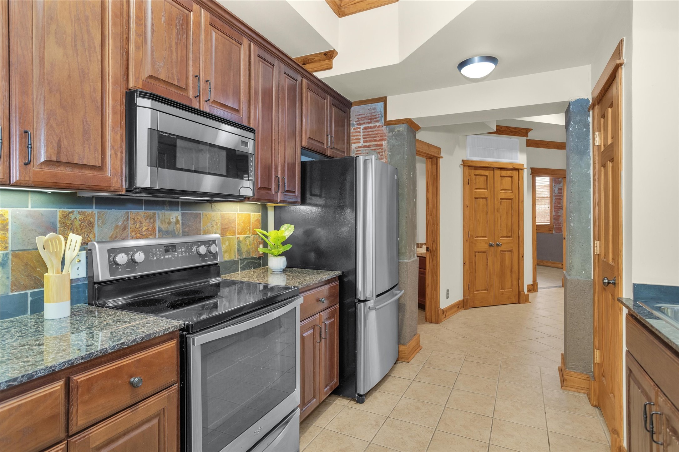 215 West Norma Street, Unit 104 Houston, TX 77009 - Photo 20 of 37 a kitchen with stainless steel appliances granite countertop a refrigerator a stove and a sink