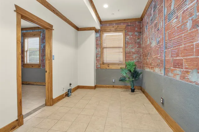 a view of a hallway with wooden floor and a bathroom