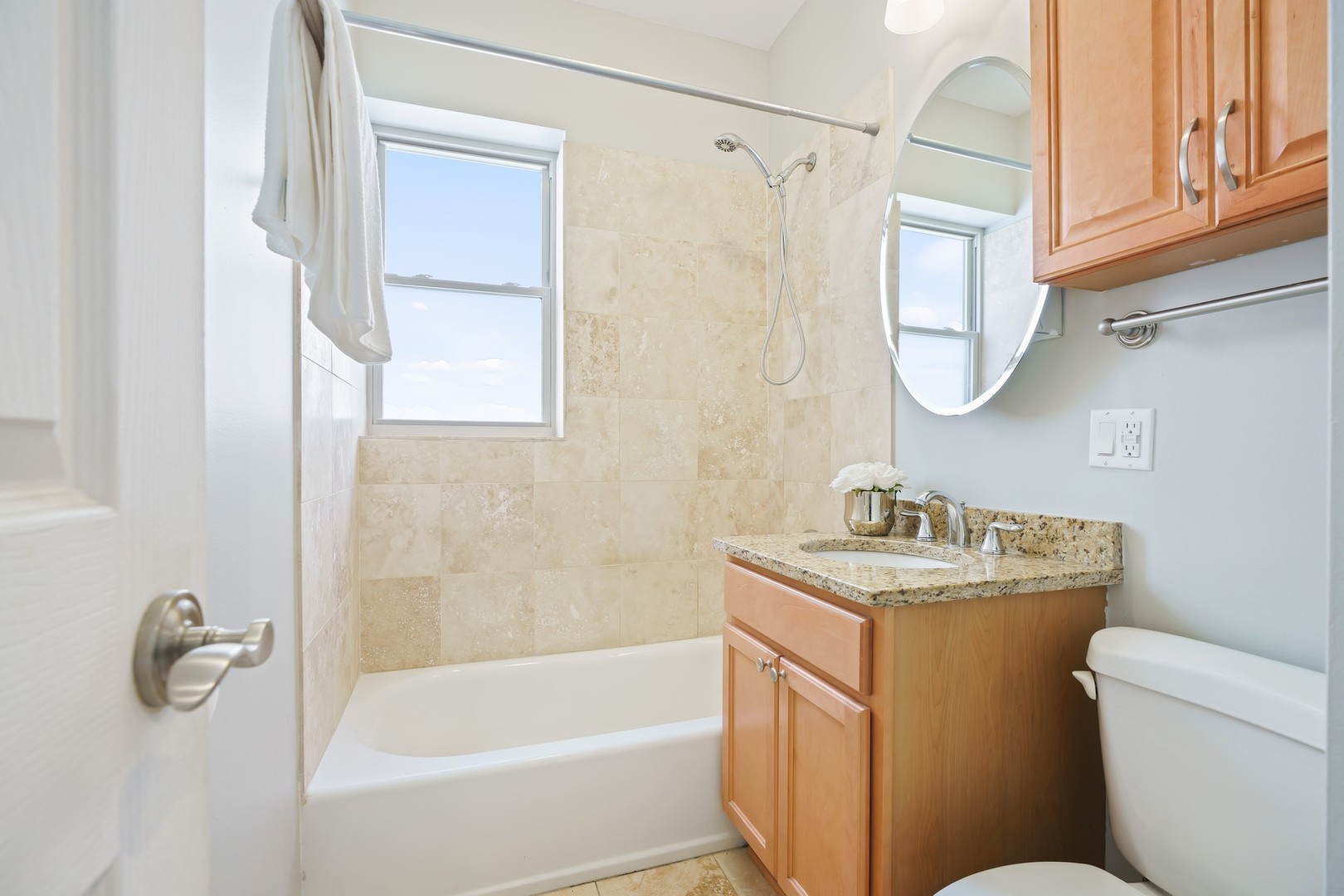 4344 North Spaulding Avenue, Unit 2 Chicago, IL 60618 - Photo 12 of 15 a bathroom with a granite countertop sink a toilet and a bathtub