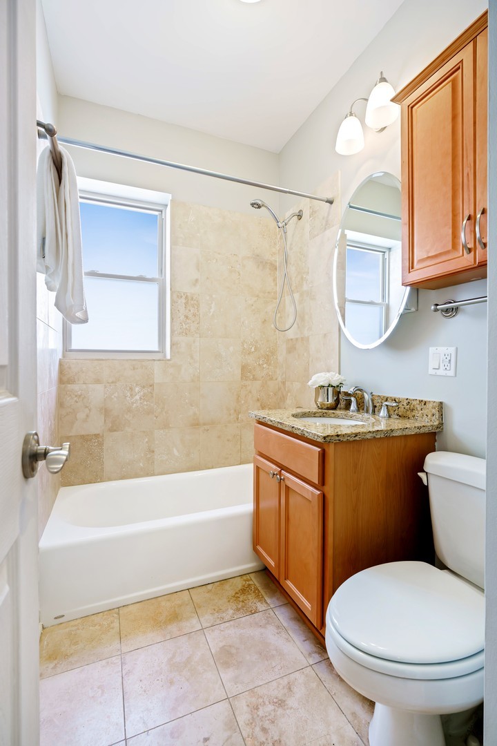 4344 North Spaulding Avenue, Unit 2 Chicago, IL 60618 - Photo 13 of 15 a bathroom with a granite countertop toilet sink and mirror