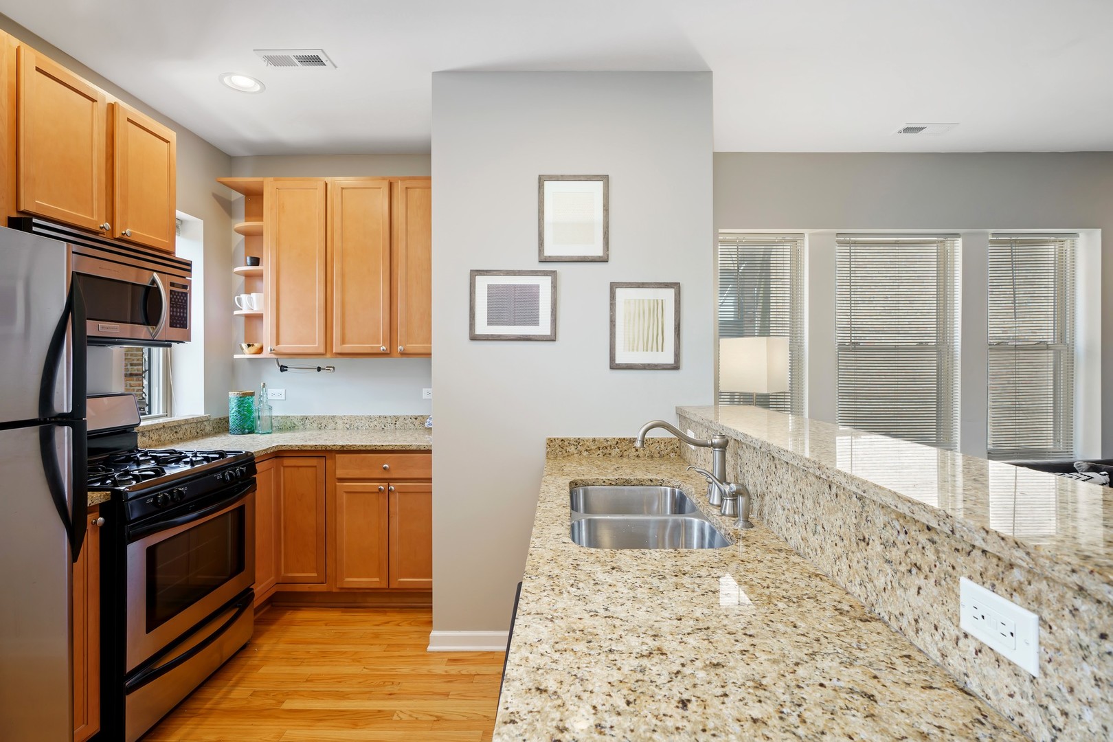 4344 North Spaulding Avenue, Unit 2 Chicago, IL 60618 - Photo 8 of 15 a kitchen with granite countertop a stove a sink and a refrigerator