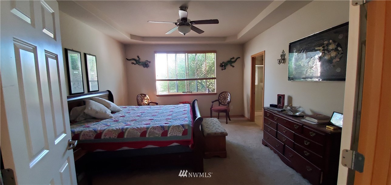 7365 Radius Loop Southeast Lacey, WA 98513 - Photo 14 of 28 a bedroom with a bed and wooden floor