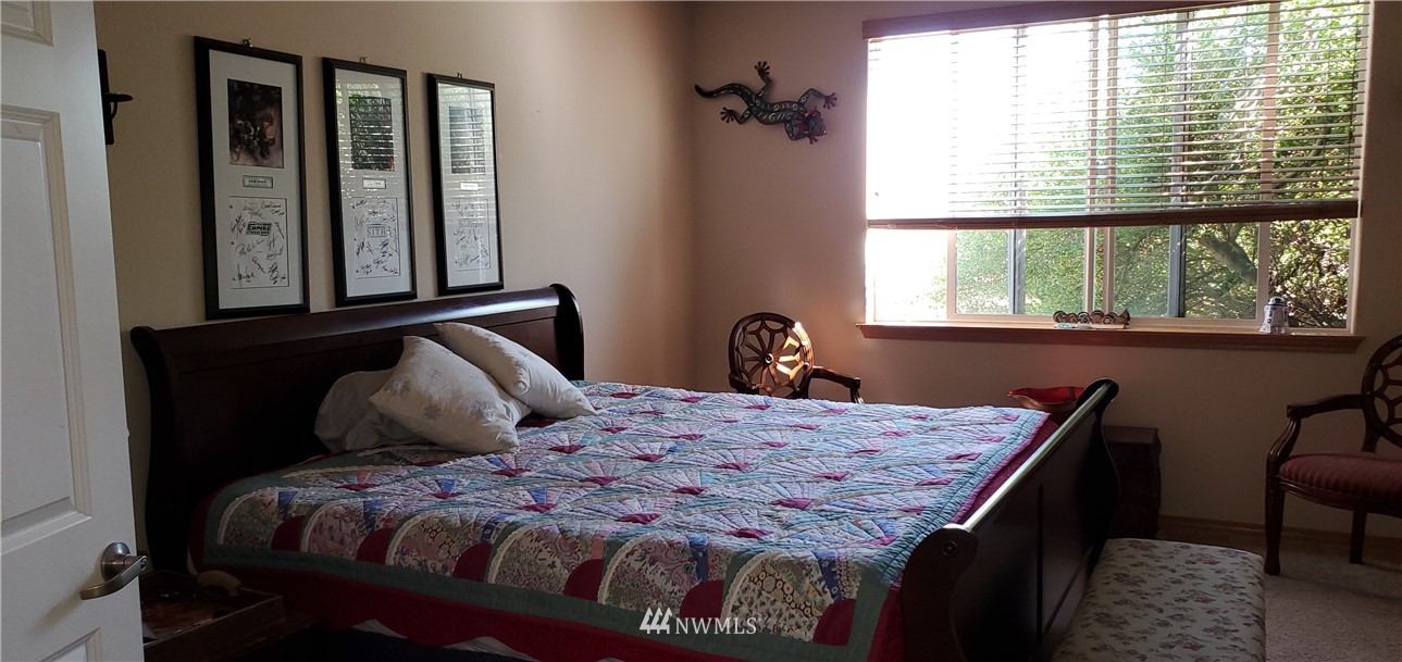 7365 Radius Loop Southeast Lacey, WA 98513 - Photo 15 of 28 a bedroom with a bed two windows and wooden floor