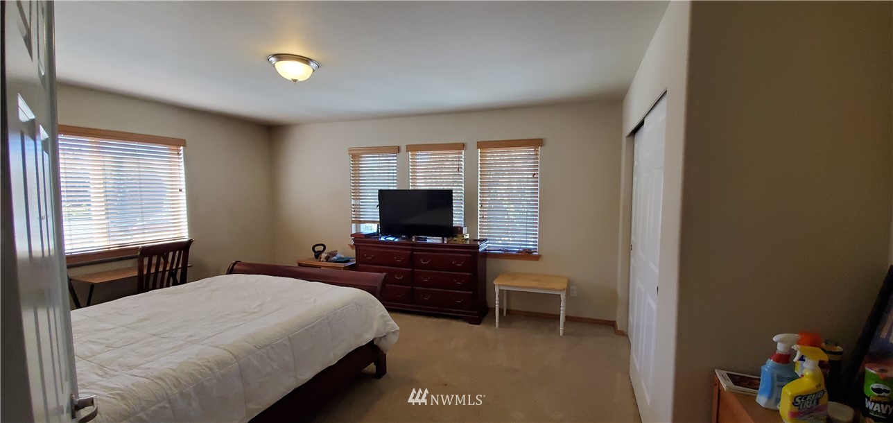 7365 Radius Loop Southeast Lacey, WA 98513 - Photo 22 of 28 a bedroom with a bed and a flat screen tv