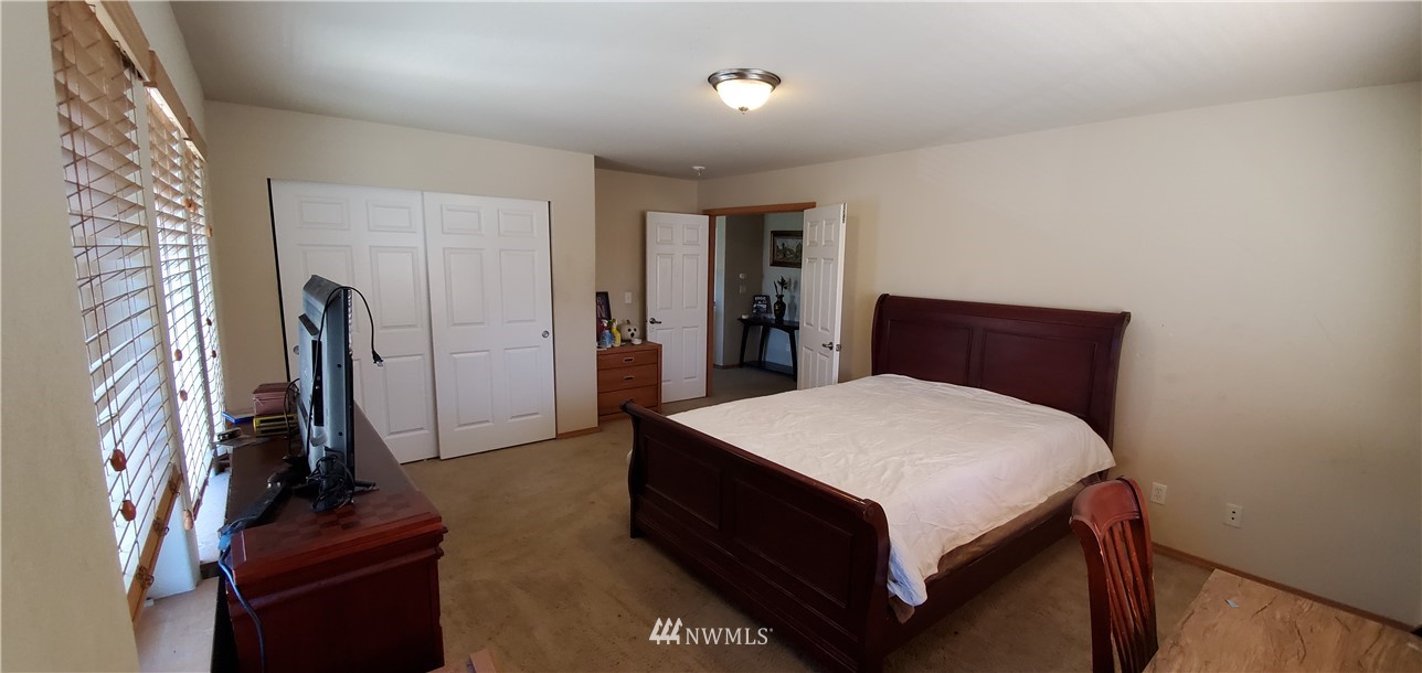 7365 Radius Loop Southeast Lacey, WA 98513 - Photo 23 of 28 a room with a bed and a flat tv screen on a dresser