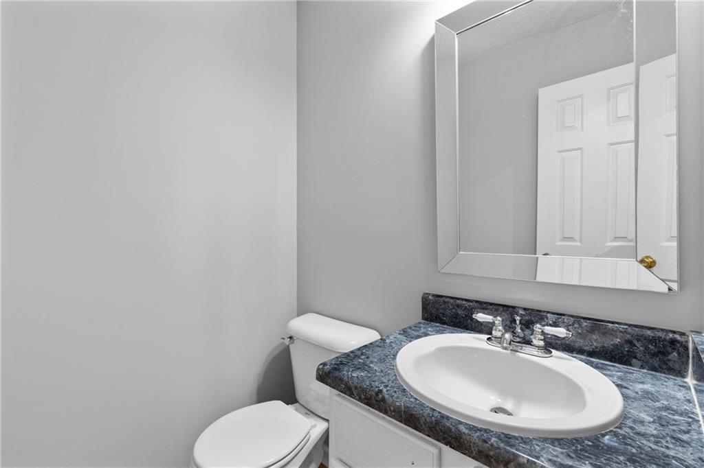 498 Pecan Wood Circle Fairburn, GA 30213 - Photo 11 of 27 a bathroom with a toilet sink and mirror