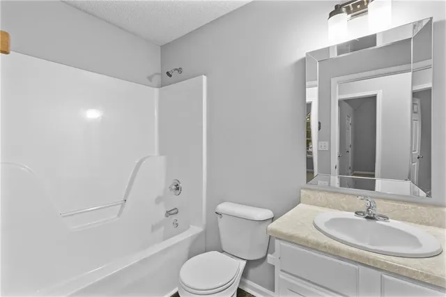 a bedroom with a bed a couch and potted plant