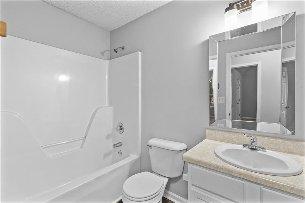 498 Pecan Wood Circle Fairburn, GA 30213 - Photo 14 of 27 a bathroom with a sink toilet and shower