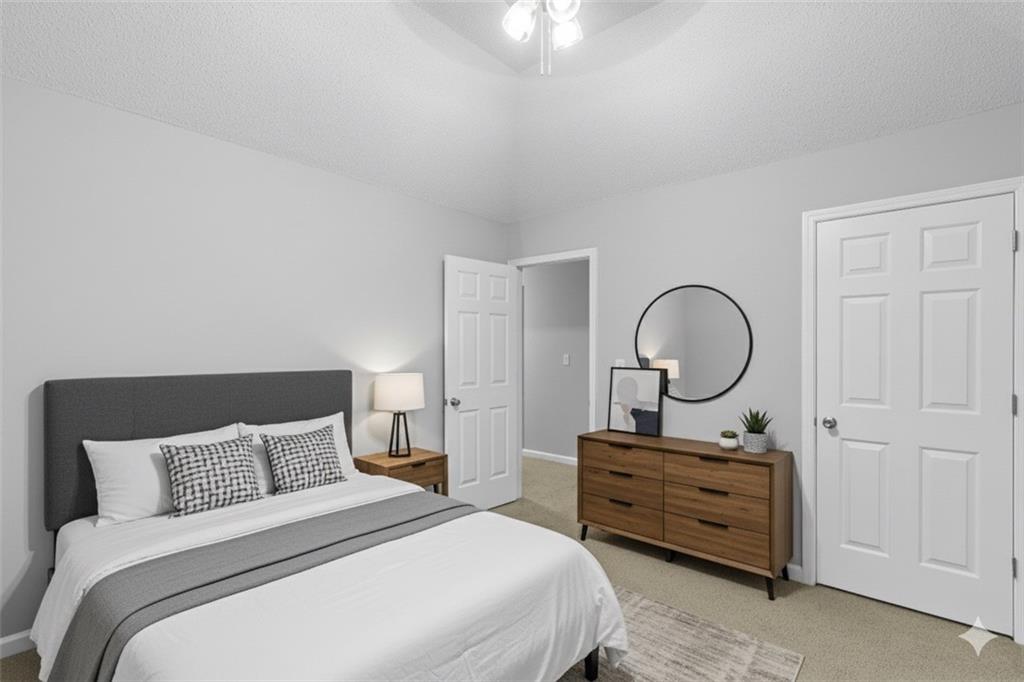 498 Pecan Wood Circle Fairburn, GA 30213 - Photo 19 of 27 a bedroom with bed and a chandelier