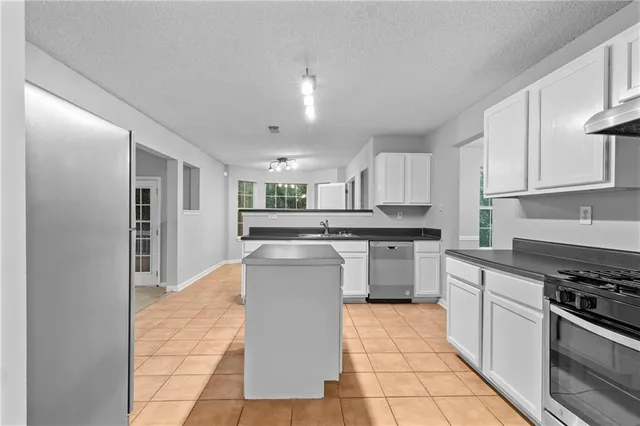 a kitchen with stainless steel appliances granite countertop a stove top oven a sink a counter top space and cabinets