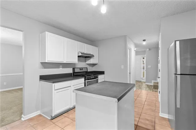 a kitchen with stainless steel appliances a stove refrigerator sink and microwave