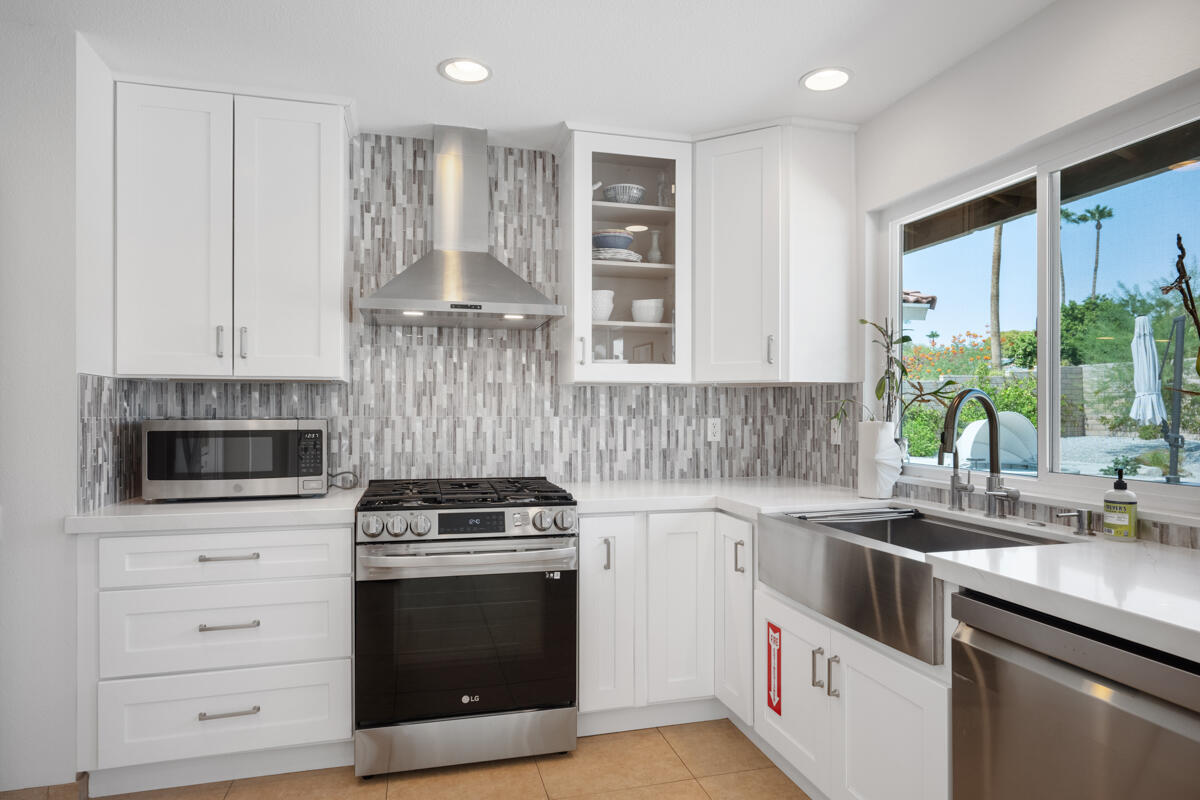 2450 Tamarisk Road Palm Springs, CA 92262 - Photo 14 of 41 a kitchen with stainless steel appliances white cabinets and a stove top oven