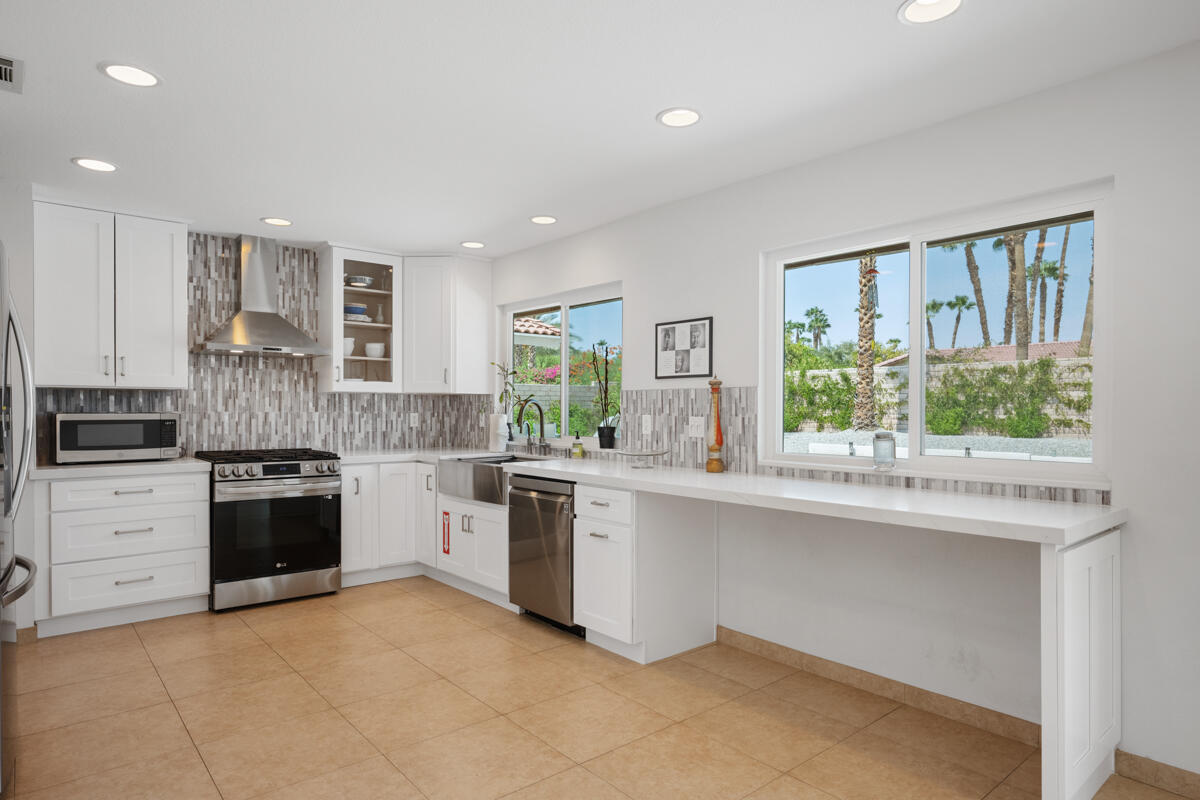 2450 Tamarisk Road Palm Springs, CA 92262 - Photo 4 of 41 a kitchen with a stove a sink and a microwave