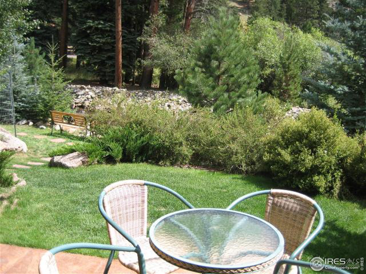 2100 Fall River Road, Unit 6 Estes Park, CO 80517 - Photo 5 of 6 a backyard of a house with a yard fountain and outdoor seating