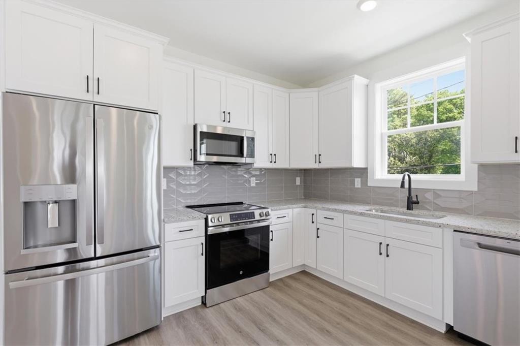 208 Mission Way Atlanta, GA 30315 - Photo 6 of 43 a kitchen with granite countertop white cabinets and stainless steel appliances