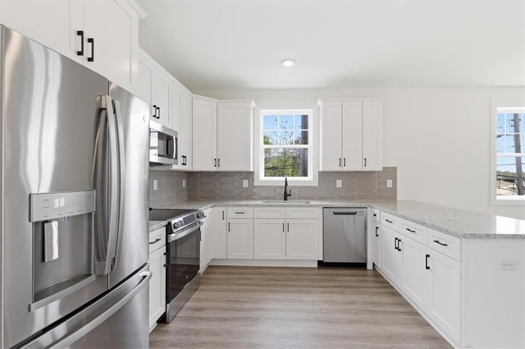 208 Mission Way Atlanta, GA 30315 - Photo 7 of 43 a kitchen with white cabinets and stainless steel appliances
