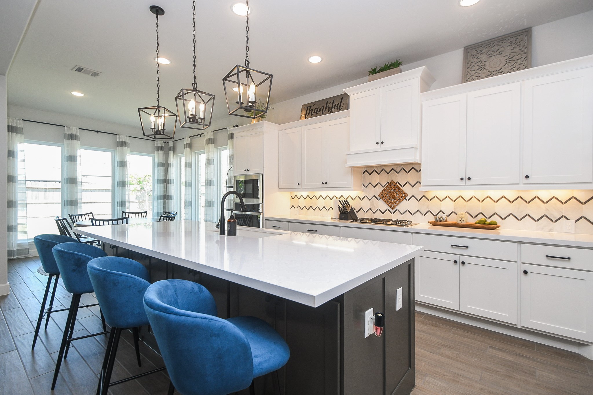 30314 Brook Point Fulshear, TX 77441 - Photo 11 of 38 Marble backsplash accompanied by matte black fixtures and pulls adds elegance to the space.