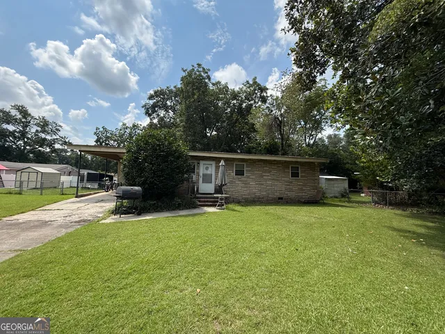 a view of backyard with a table and chairs and potted plants