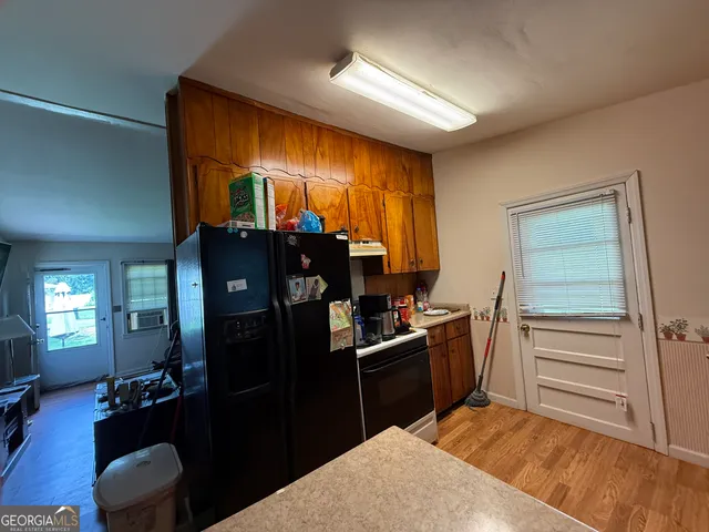 a kitchen with a refrigerator and a stove top oven