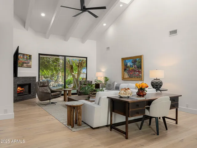 a living room with fireplace furniture and a large window