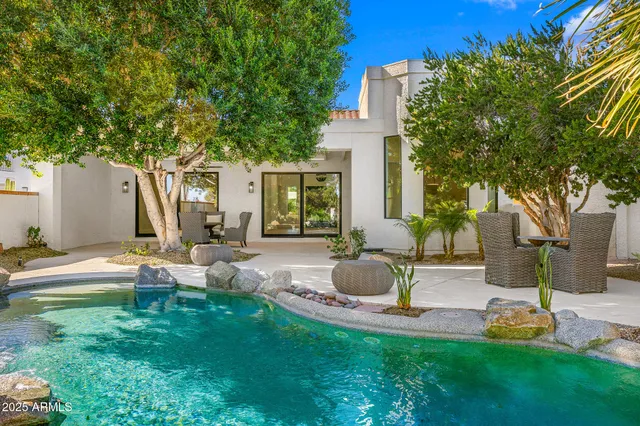 a view of backyard of house with outdoor seating and green space