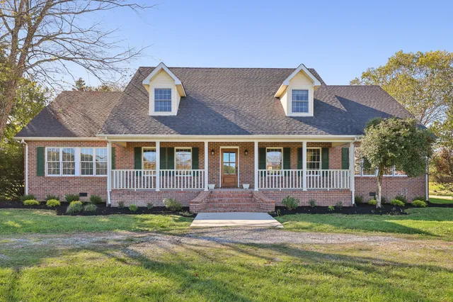 a front view of a house with a yard and trees